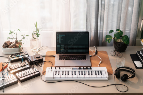 Desk With Music Instruments, Synthesizers And A Laptop Computer photo