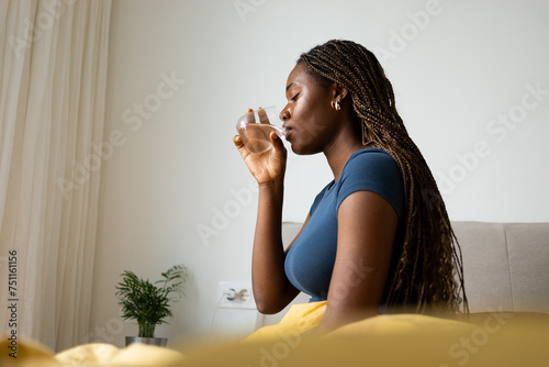Woman Sitting on Bed, Drinking Water  photo