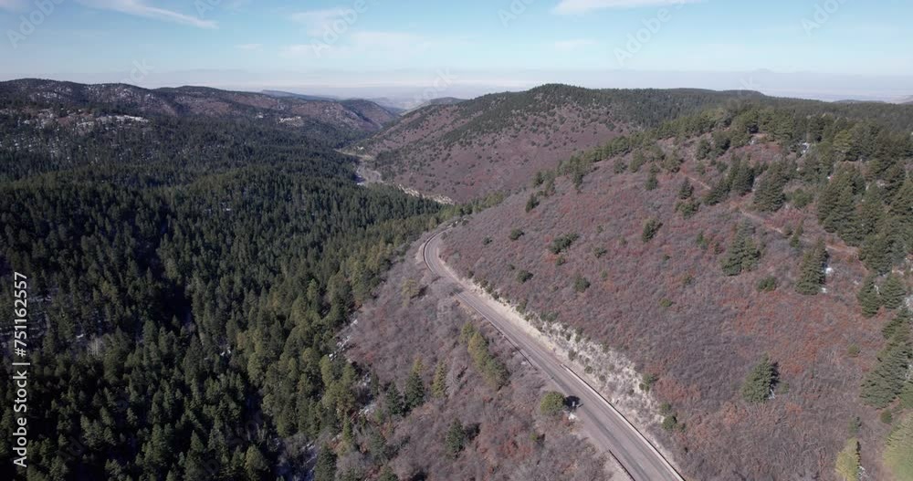 Drone shot of a mountain highway and pine tree forest Drone shot of a mountain highway and pine tree forest
