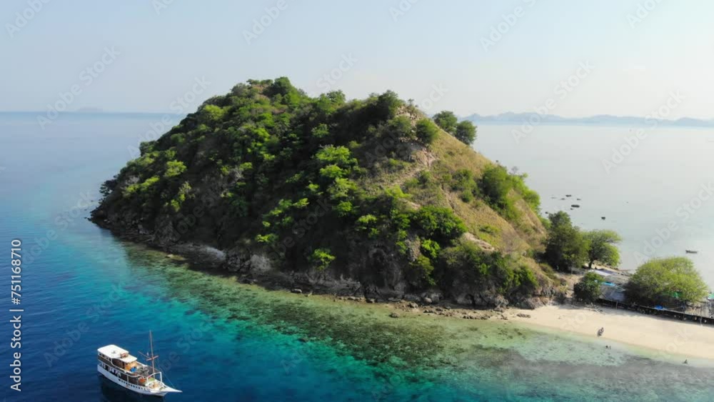 small Pulau Kelor island in Komodo Park, Indonesia, shot from a drone circling around it to showcase its beauty from all angles. Orbit shot to the right.