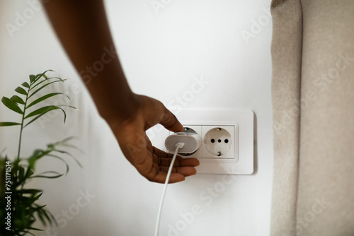 Woman Putting Plug Into Socket  photo