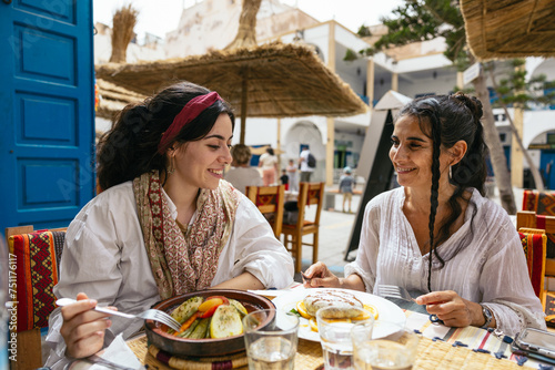 mother and daughter eating typical food during their trip to Morocco. photo