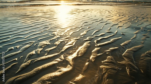 Abstract patterns of light and shadow on a sandy beach.