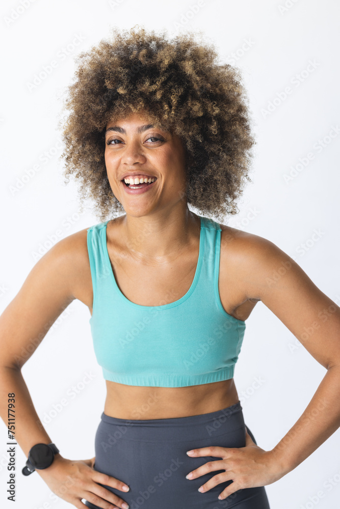 Young biracial woman smiles confidently in sportswear