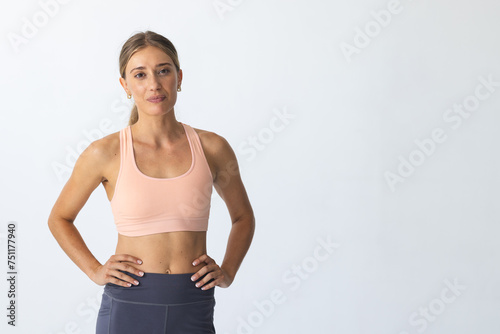 Young Caucasian woman stands confidently in sportswear, with copy space