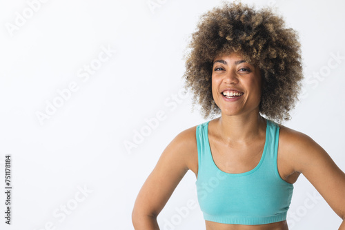 Young biracial woman smiles brightly in a fitness setting with copy space