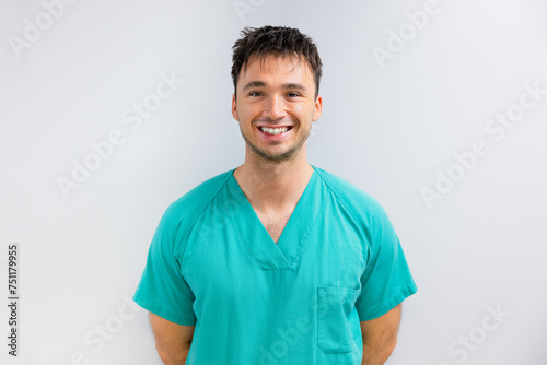 Portrait of cheerful young male surgeon in scrubs photo