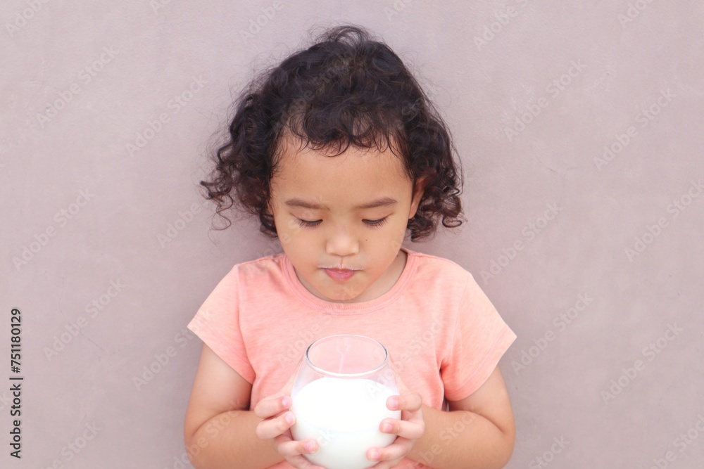 Expression of a toddler girl drinking milk in a glass. Expression of a toddler girl drinking milk in a glass.