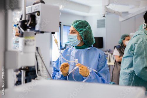Woman doctor in uniform and cap standing near equipment photo