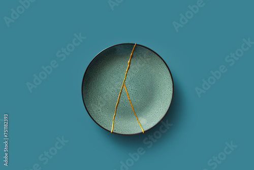 Green plate with gold kintsugi lines. photo