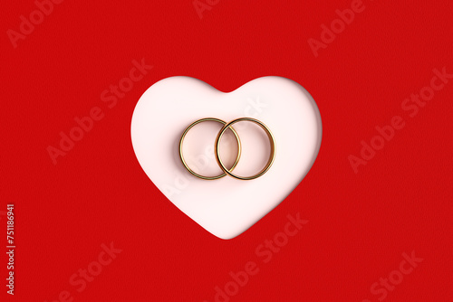 Golden wedding rings inside of a cut out heart shape on red background.