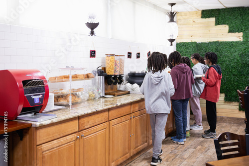 Children getting food from a hotel continental breakfast. photo