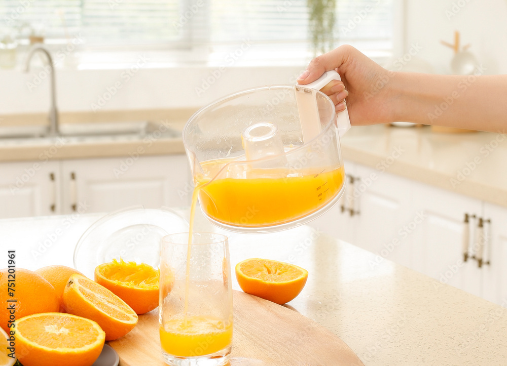 Pour freshly squeezed orange juice from the juicer Pour freshly squeezed orange juice from the juicer
