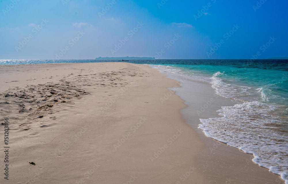 Large sandy beach with a view of the ocean and an island on the horizon. Large sandy beach with a view of the ocean and an island on the horizon.