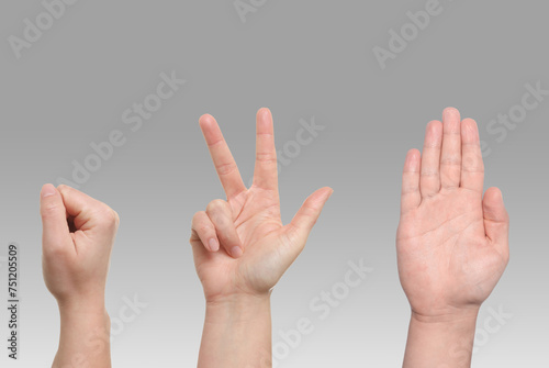 People playing rock, paper and scissors on grey background, closeup