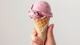 Hand holding blueberry ice cream cone on white background