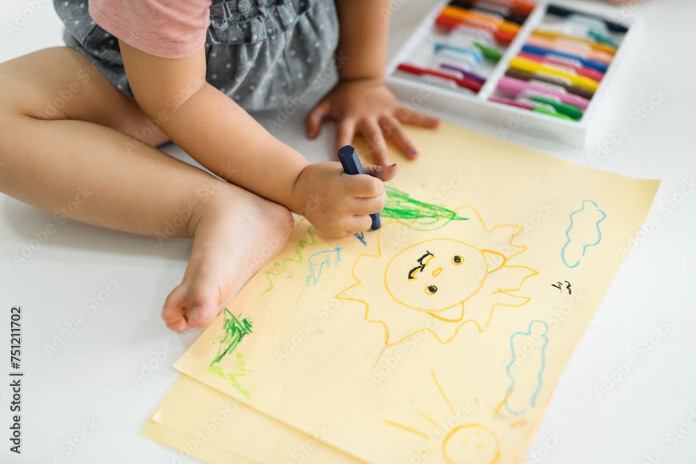 The child's hands are painted with colored crayons on a paper sheet The child's hands are painted with colored crayons on a paper sheet