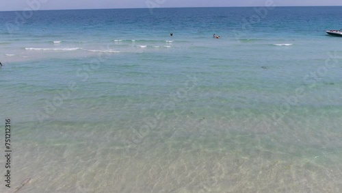 Drone aerial view in Vietnam flying over Phu Quoc island Sao beach, crystal clear blue turquoise water, small waves and people swimming on a sunny day photo