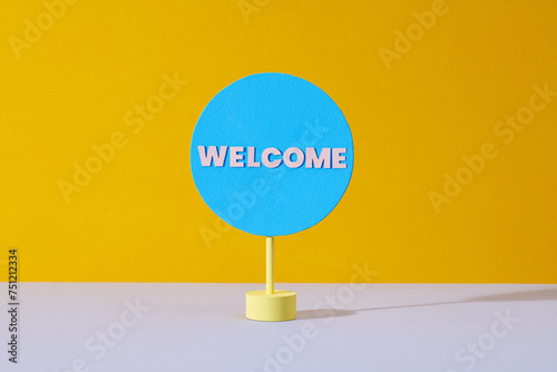 Welcome - text on a little circle on yellow bright background photo