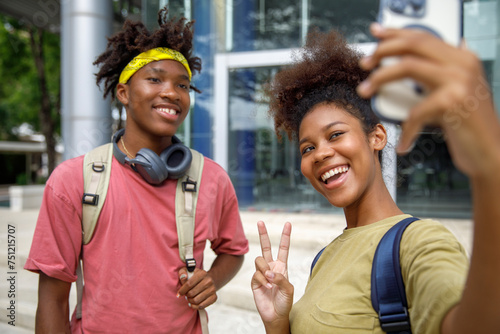 Happy teenage friends taking selfies on mobile phone  photo
