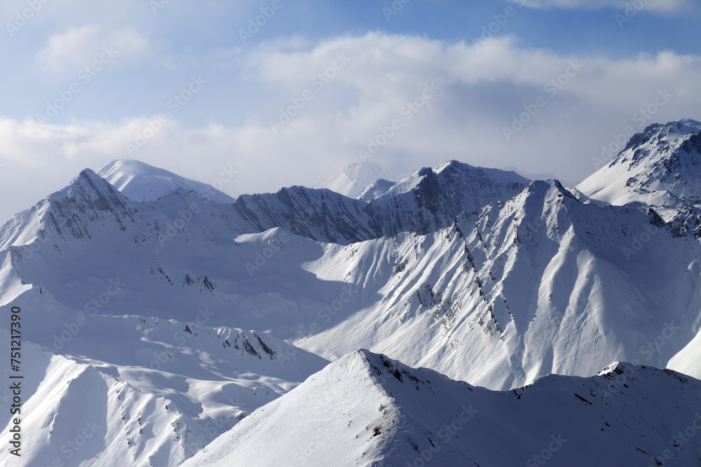 Naklejka premium Snowy mountains in clouds