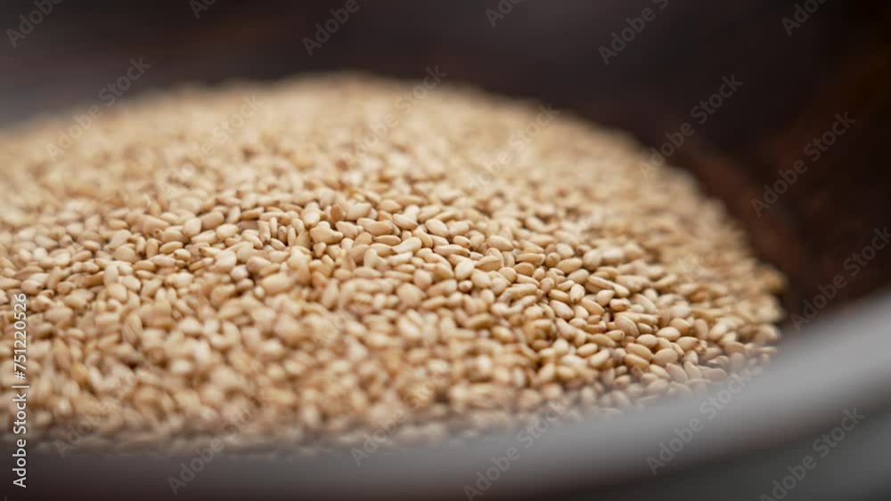 Sesame seeds in a rustic wooden bowl. Traditional Indian Asian spices close up. Rotation Sesame seeds in a rustic wooden bowl. Traditional Indian Asian spices close up. Rotation