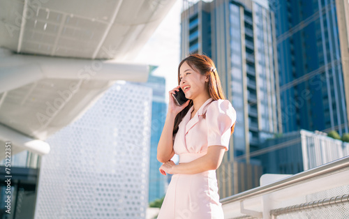 Shot of elegant young business woman smiling and using mobile phone while walking, Copy space. © kelvn