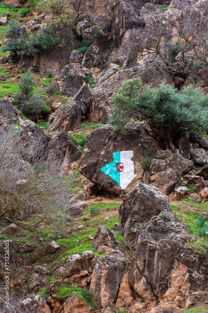Low-angle view of the Algeria flag painted on a rock formation in the mountain. Low-angle view of the Algeria flag painted on a rock formation in the mountain.