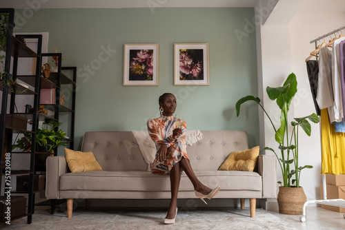 Black woman in stylish dress sitting with wineglass photo