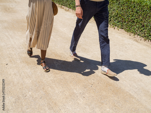 Crop diverse couple walking on summer day