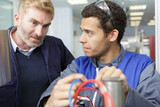 worker holding blue and red cables