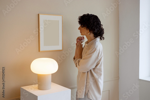 Young woman in stylish, modern room with mockup frame   photo
