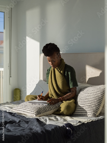 Woman taking notes in notepad during home education