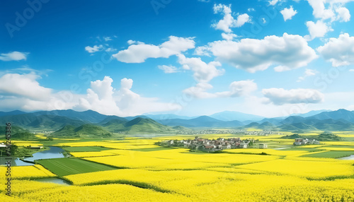 A beautiful countryside with a yellow field and a road leading to a village