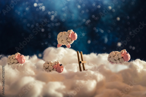 Cute plasticine sheep jumping over a fence in the clouds. photo