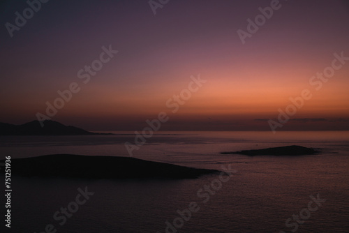 Sunset view from Monteferro's Rosa dos Ventos viewpoint, showcasing a serene horizon over tranquil seas. Silhouettes of Estelas Islands and distant Cabo Silleiro under a vibrant orange and purple sky. photo