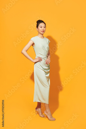 Full length portrait of happy beautiful woman in mint dress posing