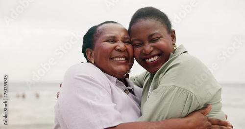 Happy, mother and daughter hug at beach with love and happiness on holiday or travel on vacation together. African, family and black woman embrace mature mom at ocean or sea with kindness and support photo