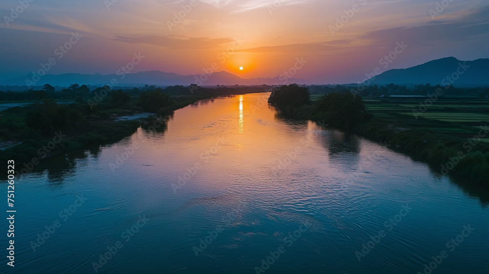 A tranquil river flowing gently through the countryside, reflecting the vibrant hues of the sunset sky, creating a breathtaking backdrop for Eid ul Azha celebrations.