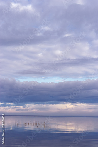 Beautiful white blue clouds over lake  symmetric sky background  cloudscape on lake Ik  Russia. Nature abstract  cloudy sky reflected on water  calm windless weather  natural environment