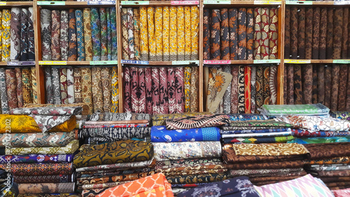 Stacking piles of batik cloth clothes in a batik shop. Batik is traditional Indonesian clothing