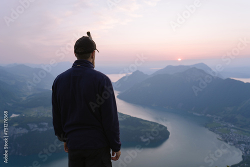 Male Tourist observing mountain lake at sunset