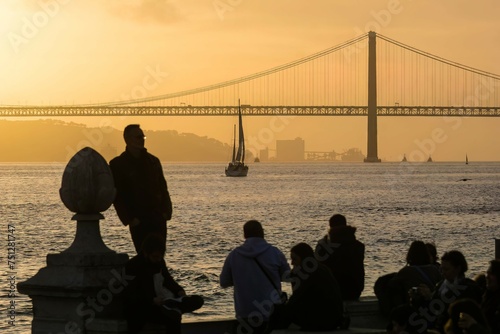 People watching the sunset over the Tagus river in Lisbon, Portugal