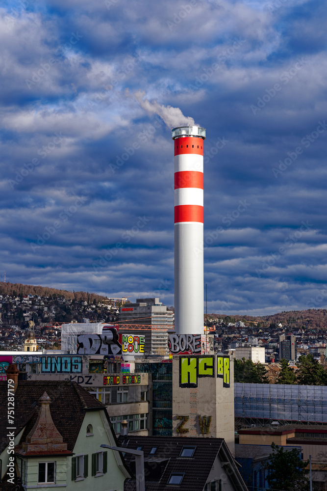 Skyline of industrial district with concrete chimney of district heating at Swiss City of Zürich on a cloudy winter afternoon. Photo taken February 23rd, 2024, Zurich, Switzerland.