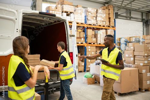 Workers Loading Delivery Van In The Warehouse photo