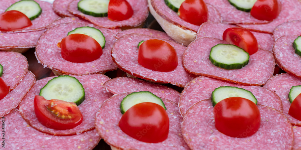 Brötchen mit Mettwurstscheiben belegt dazu geschnittene Gurke und Tomate Brötchen mit Mettwurstscheiben belegt dazu geschnittene Gurke und Tomate