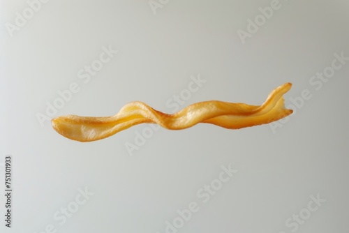 captivating image of golden French fries in mid-air, creating a sense of motion against a soft grey backdrop