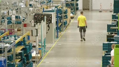 Wallpaper Mural Factory Worker in a Yellow T-Shirt Walking by Lined up Modern Injection Moulding Machines for Automotive Industry Torontodigital.ca