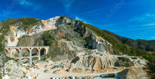 A panoramic view of a marble quarry in Tuscany with the old railway bridge.