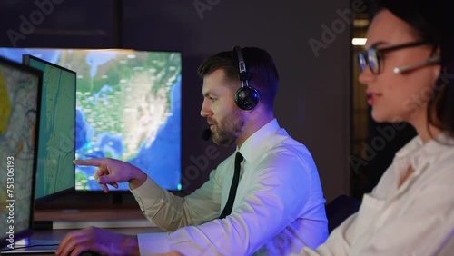 Air traffic controller in headphones talking with the pilot of the plane in air traffic control room photo